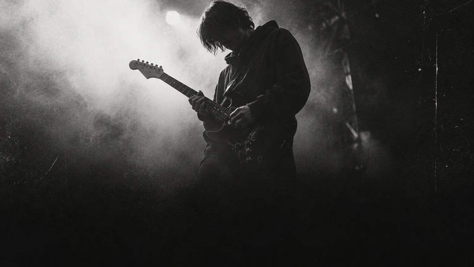 A guitarist playing an electric guitar in stage haze
